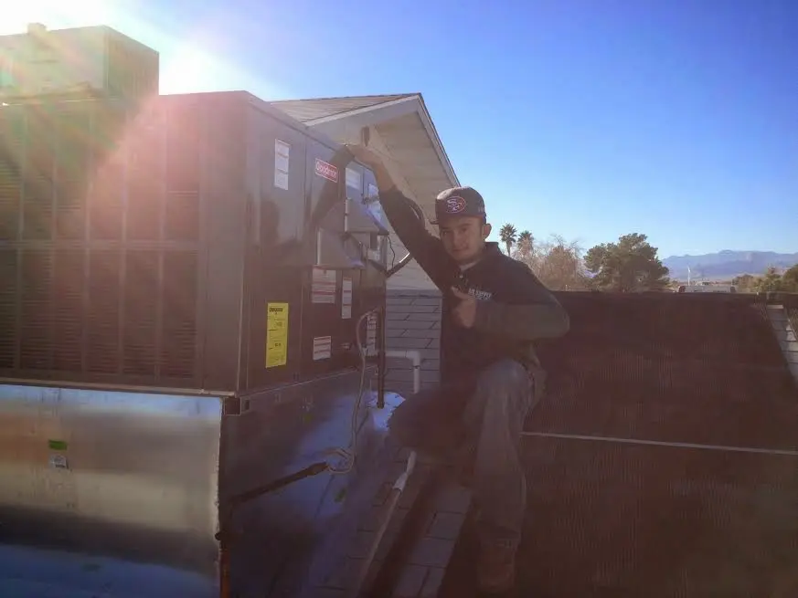 HVAC technician performing Heat Pump Repair on a rooftop unit in Whitehouse